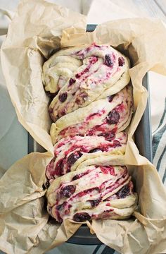 a pan filled with pastries sitting on top of paper wrapped in brown paper wrappers