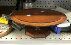 a wooden table sitting on top of a shelf next to some other items in a store