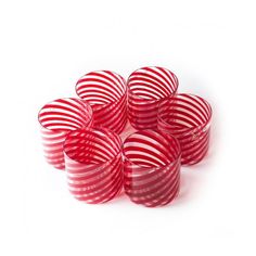 red and white striped glasses sitting in a circle on a white surface with no one around them