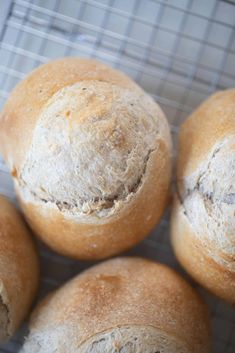 four loaves of bread sitting on top of a cooling rack