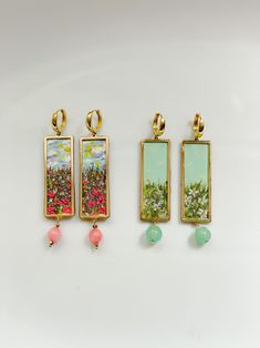 *please note these available for pre-order, with an estimated production and shipping time of 10 to 14 business days.Bring a touch of artistry to your wardrobe with the En Rose Impressionist Painting Flower Field Earrings! These stunning handmade earrings feature a blueish green background with delicate daisies "painted" in an impressionist style. Each earring is adorned with a beautiful jade-colored glass bead, adding a pop of color and elegance. The best part? You can customize your Handmade Earrings Ideas Diy, Painted Clay Earrings, Painting Flower Field, Painting Earrings, Artsy Earrings, Blueish Green, Jewelry Making Classes, Painted Earrings, Painting Flower