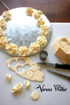 the cake is decorated with flowers and icing on the table next to some scissors