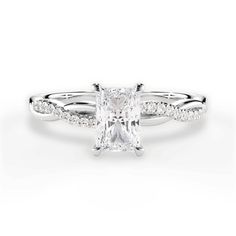 a white gold ring with a princess cut diamond in the center and pave set shoulders