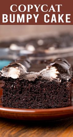 a piece of chocolate copycat bumpy cake on a plate with the rest of the cake in the background