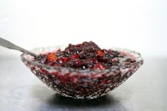 a glass bowl filled with cranberry sauce on top of a table