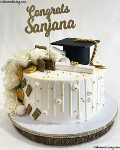 a cake decorated with flowers and graduation caps on top of a white plate that says congrats santa anana