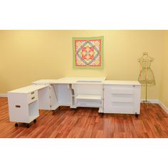 a white desk with two drawers on wheels in an empty room next to a yellow wall