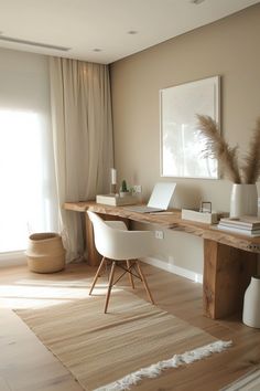 a desk with a laptop on top of it in front of a window and a rug