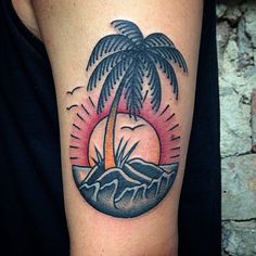 a palm tree and mountains tattoo on the arm