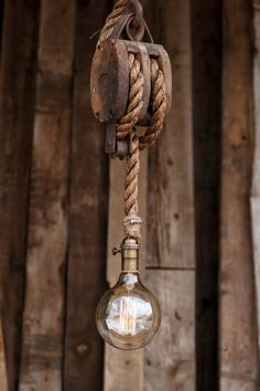 an old fashioned light bulb hanging from a rope