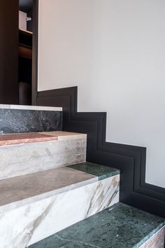 marble steps leading up to a door in a room with white walls and black trim