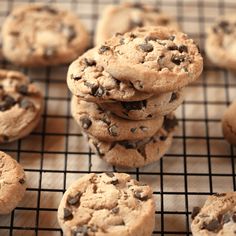 chocolate chip cookies stacked on top of each other on a cooling rack with one cookie in the middle