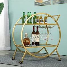 a gold bar cart with bottles and glasses on it