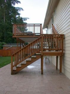 a wooden stair case next to a white house