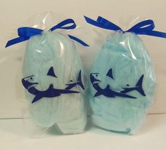 two blue shark shaped soaps wrapped in plastic with bows on the top and bottom