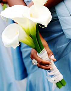 a woman holding a bouquet of white flowers