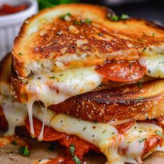 a grilled cheese sandwich with tomato sauce and parmesan cheese on the side