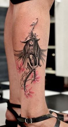 a woman's leg with a tattoo on it and an image of a demon