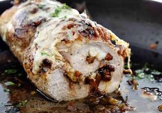 some meat is being cooked in a skillet with sauce and herbs on the side