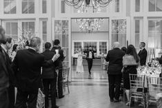 the bride and groom are walking down the aisle at their wedding ceremony in black and white