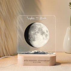 an acrylic clock with a photo of the moon on it's side