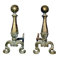 two antique style metal candlesticks with ornate designs