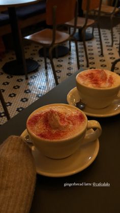 two cups of hot chocolate sit on a table