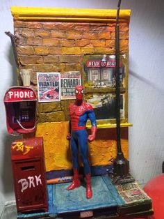 a toy spider man stands in front of a vending machine and phone booth on display