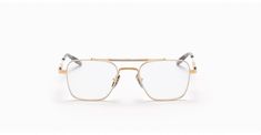 a pair of glasses sitting on top of a white surface with gold trimmings