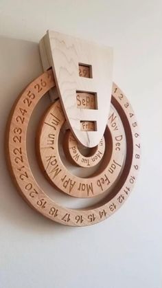 three wooden circles with numbers on them hanging from the wall