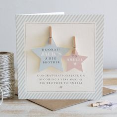 a card with two star shaped magnets attached to it's sides, next to twine of twine spools