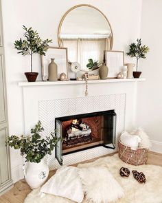 a living room with a fireplace, mirror and potted plants on the mantel