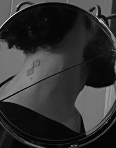 the reflection of a woman's face in a mirror with her hair pulled back