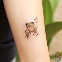 a small frog tattoo on the arm