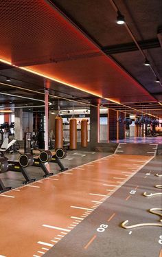 an empty gym with rows of machines and treadmills on the floor at night