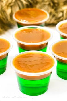 small cups filled with caramel sauce sitting on a white counter top next to a cat