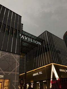 a building with the name pavilion on it's side and people walking around outside