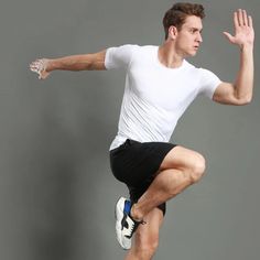 a man in white shirt and black shorts jumping