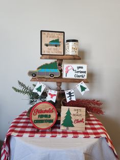 there is a christmas tree on top of a table with decorations and signs around it