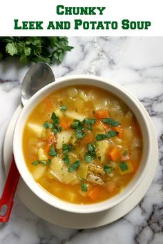 a bowl of soup with carrots, celery and parsley in it