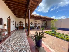 an outdoor patio area with potted plants on the ground and tiled flooring in front of it