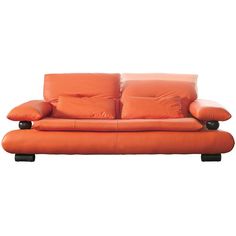 an orange leather couch with black legs and two pillows on the back, against a white background