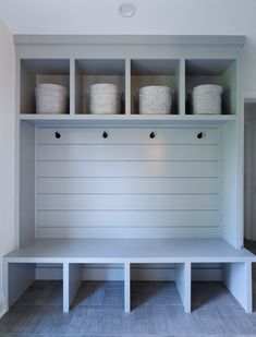 a white bench with baskets on it in a room