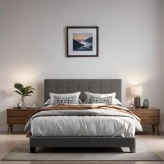 a bedroom with a bed, nightstands and pictures hanging on the wall above it