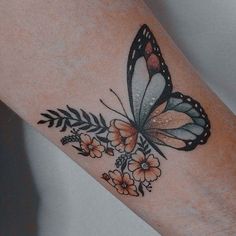 a woman's arm with a butterfly and flowers tattoo on it