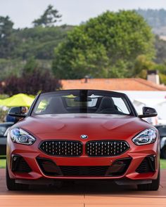 a red bmw z4 convertible parked in front of other cars