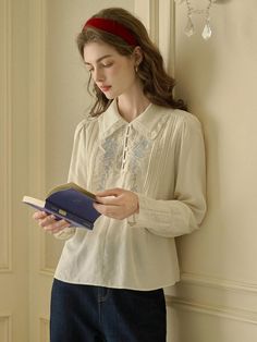 This Rose Embroidery Shirt exudes vintage charm, featuring intricate embroidery on the front that brings a touch of elegance to the classic silhouette. Its soft collar and button-down design make it a versatile piece that pairs well with both formal and casual attire. Delicate lace detailing along the cuffs and collar adds a sophisticated and timeless finish. - Crafted with attention to detail, the shirt includes pin-tuck accents along the front panel.- The back of the shirt is kept simple, ensuring the focus remains on the beautiful embroidery work.- It's designed with long sleeves and buttoned cuffs, offering a tailored and comfortable fit.- Made from a breathable fabric, it is ideal for both cool and warm weather, transitioning effortlessly between seasons. Feminine Floral Embroidered Blouse With Collar, Floral Embroidered Blouse With Collar, Spring Semi-formal Cotton Blouse, Semi-formal Spring Cotton Blouse, Spring Floral Embroidery Blouse With Collared Neckline, Spring Blouse With Floral Embroidery And Collared Neckline, Elegant Cotton Shirt With Floral Embroidery, Elegant Long Sleeve Embroidered Shirt, Elegant Embroidered Tops For Work