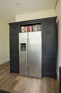 a stainless steel refrigerator and bookcase in a room