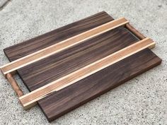 a wooden tray sitting on top of a cement floor next to a white and brown wall