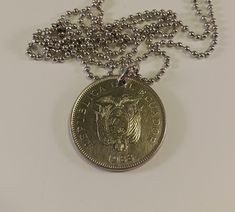 This is a coin necklace made with a coin from Ecuador.  The coin is silver in color and 1 1/8 inch in size.  It hangs from a silver ball chain necklace that is 30 inches long.  This coin has been cleaned and polished.  I only use real coins for my coin jewelry. The front of the coin shows the Republic of Ecuador coat of arms.  The year is 1988 and the value id 50 Sucres.  Like many countries the designs on the coins from Ecuador do not reverse. Necklace Made Dallas, Luxury Tarnish-resistant Sterling Silver Coin Necklace, Vintage Tarnish-resistant Coin Necklace With Round Pendant, Cheap Antique Coin-shaped Necklaces, Antique Nickel-free Silver Coin Necklace, Vintage Tarnish-resistant Coin Necklace, Coin Bracelet, Turquoise Earrings Dangle, Ball Chain Necklace